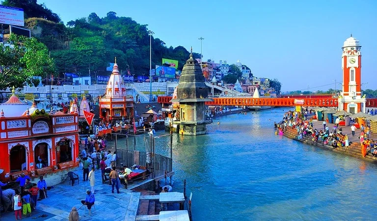 Top 12 Beautiful Hill Stations & Spiritual Destinations in Uttarakhand Haridwar with a river with people walking on it