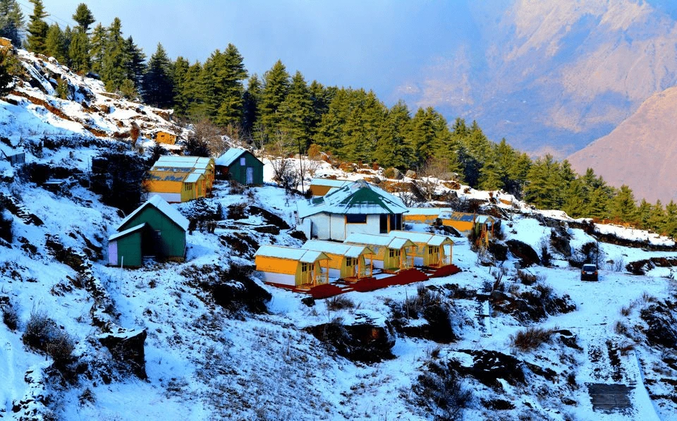 Top 12 Beautiful Hill Stations & Spiritual Destinations in Uttarakhand Auli having a group of houses on a snowy hill