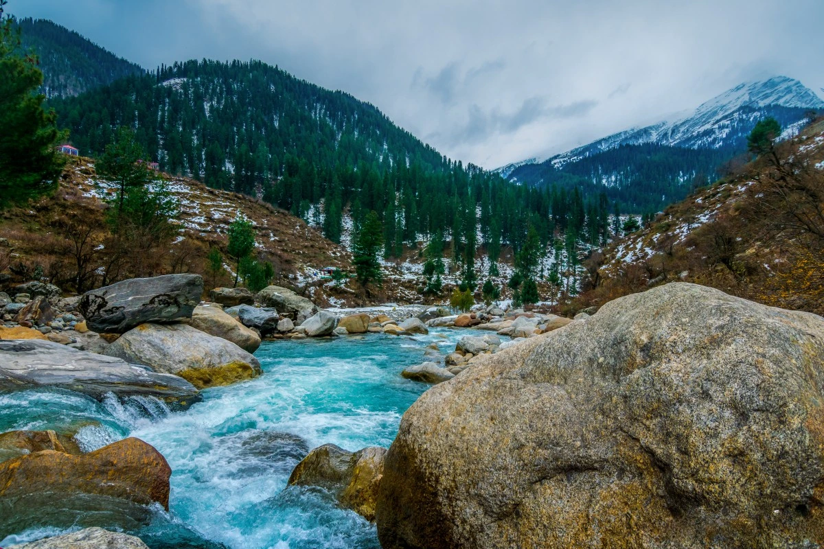 Top 10 Must-Visit Tourist Destinations in Himachal Pradesh a river running through a snowy valley in kasol